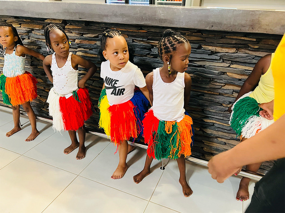 Young girls in coloured grass skirts lined up to dance